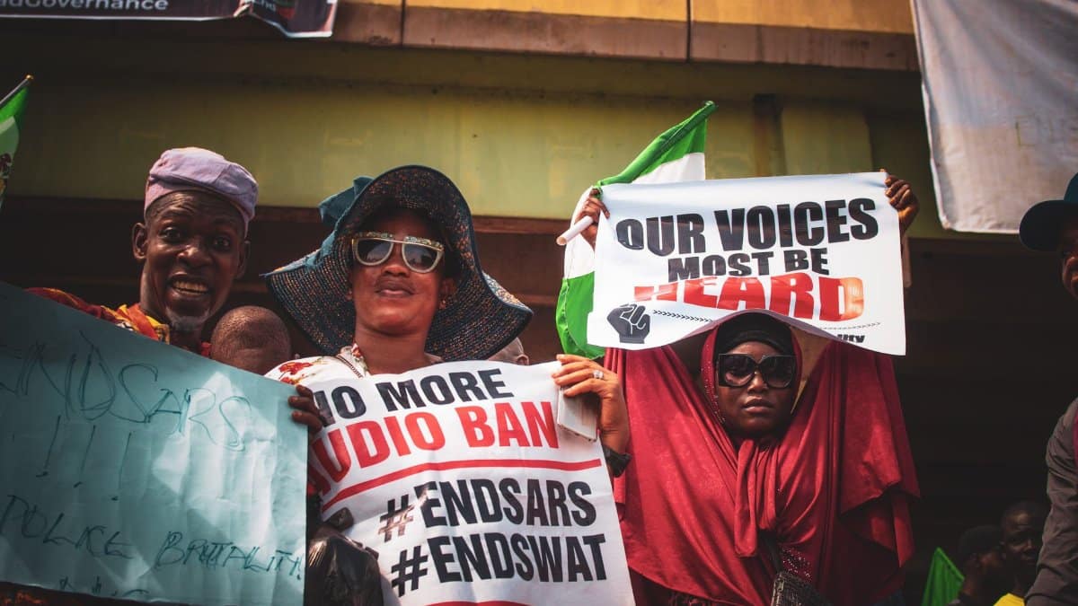 Protesters holding placards at an EndSARS rally in Nigeria, demanding justice and reform.