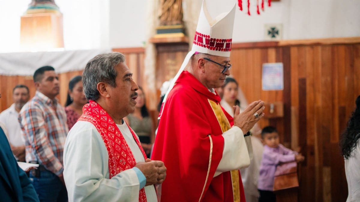 Catholic priest in traditional vestments during a religious ceremony in a church setting.