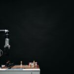 An articulated robotic arm competes in chess on a board against a dark background, highlighting AI and innovation.
