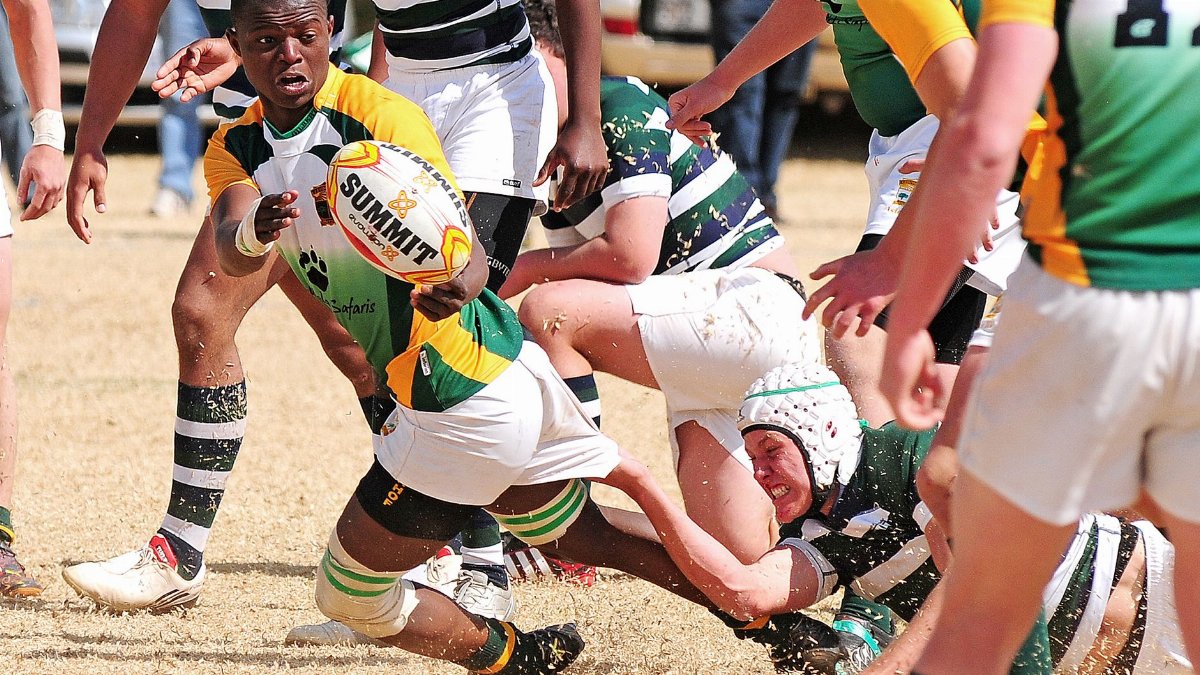 Dynamic scene capturing a high-intensity rugby match with diverse players in action.
