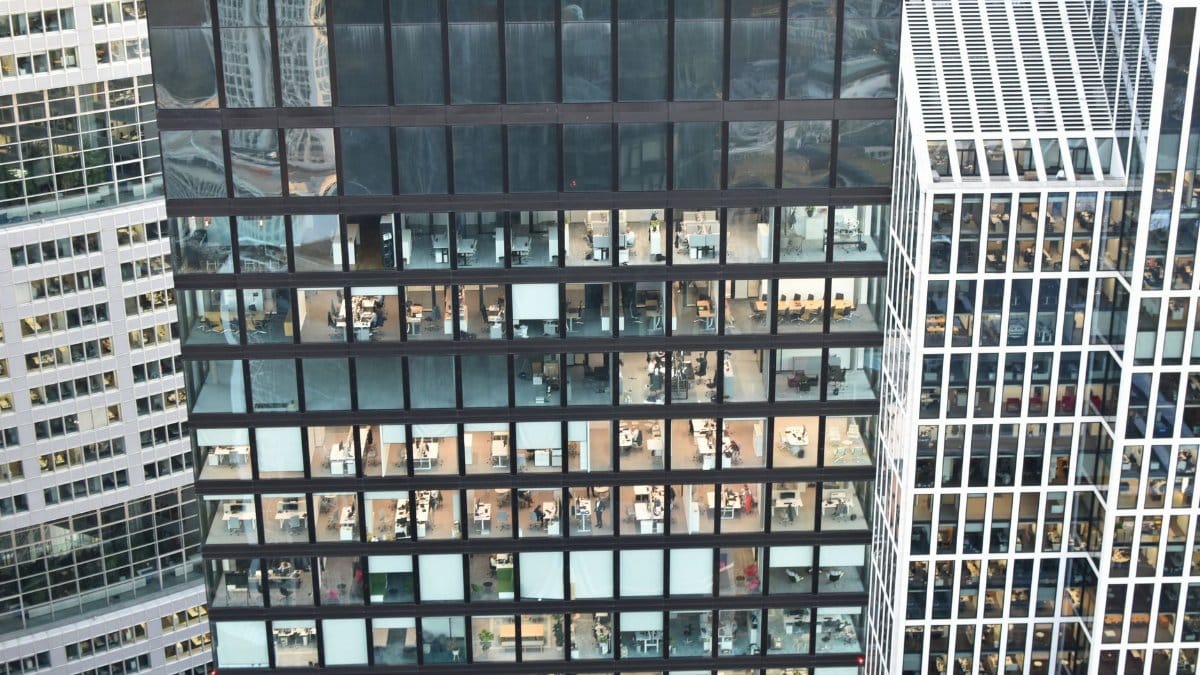 High-rise building facade with visible office interiors, showcasing urban architecture.
