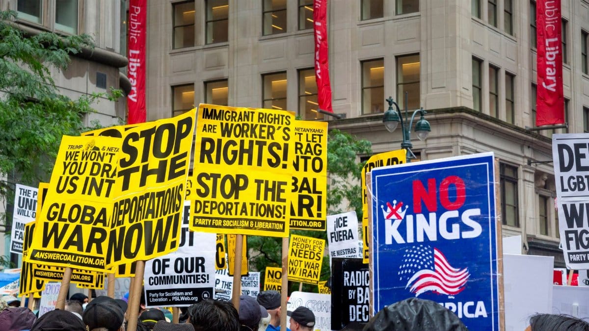 Vibrant protest with signs demanding rights and opposing deportations.