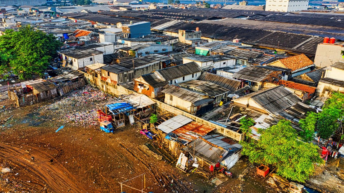 Aerial shot depicting urban slums in Jakarta with visible pollution and crowded housing.