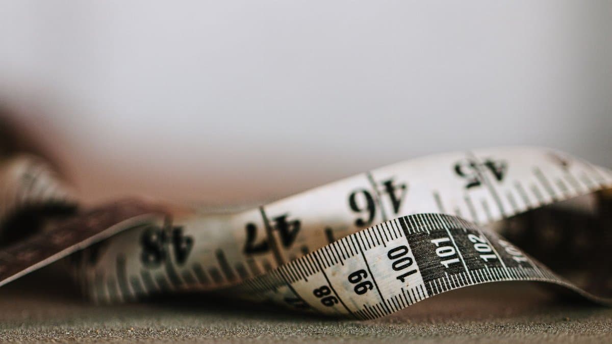 Artistic shallow focus image of a measuring tape showing numbers and units.