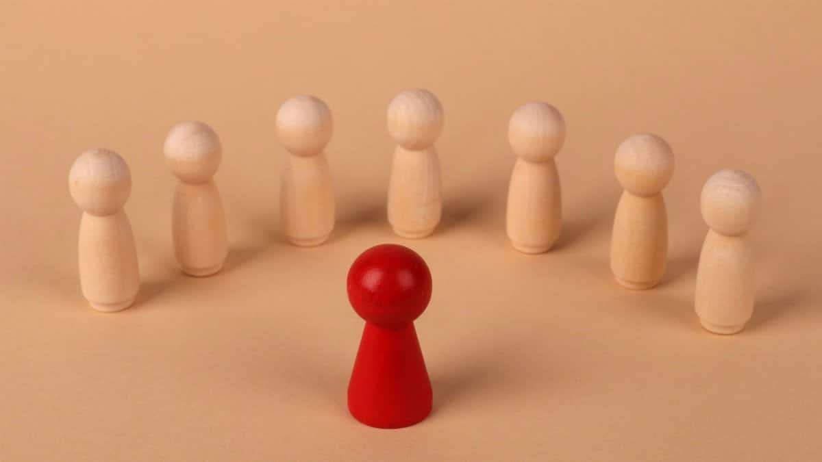 Conceptual image of leadership depicted by red and beige wooden figurines.