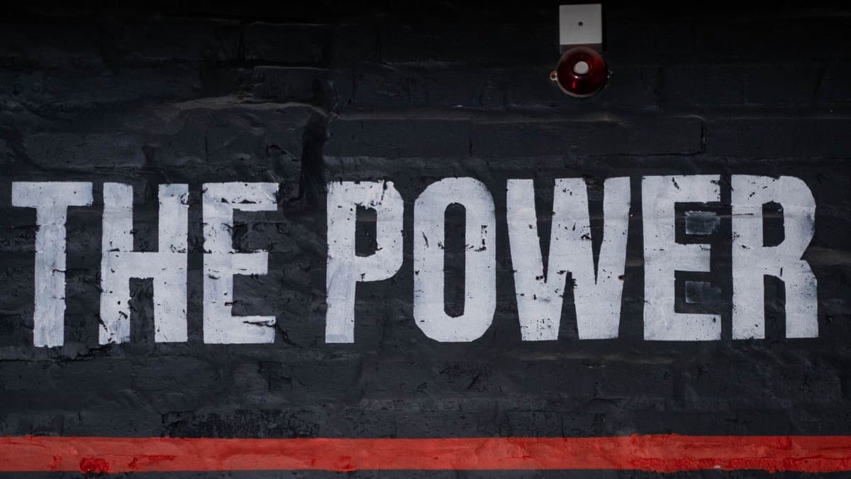 Close-up of 'The Power' graffiti on a dark wall, emphasizing strength and impact.