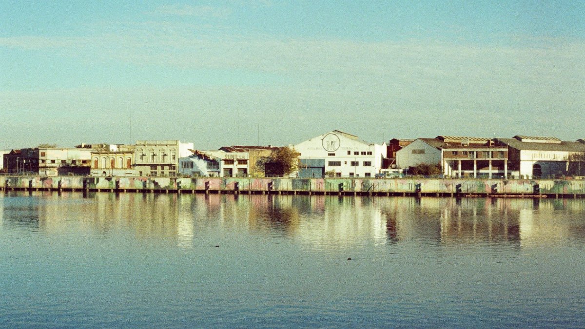 Serene city waterfront with historic architecture reflecting on calm water.