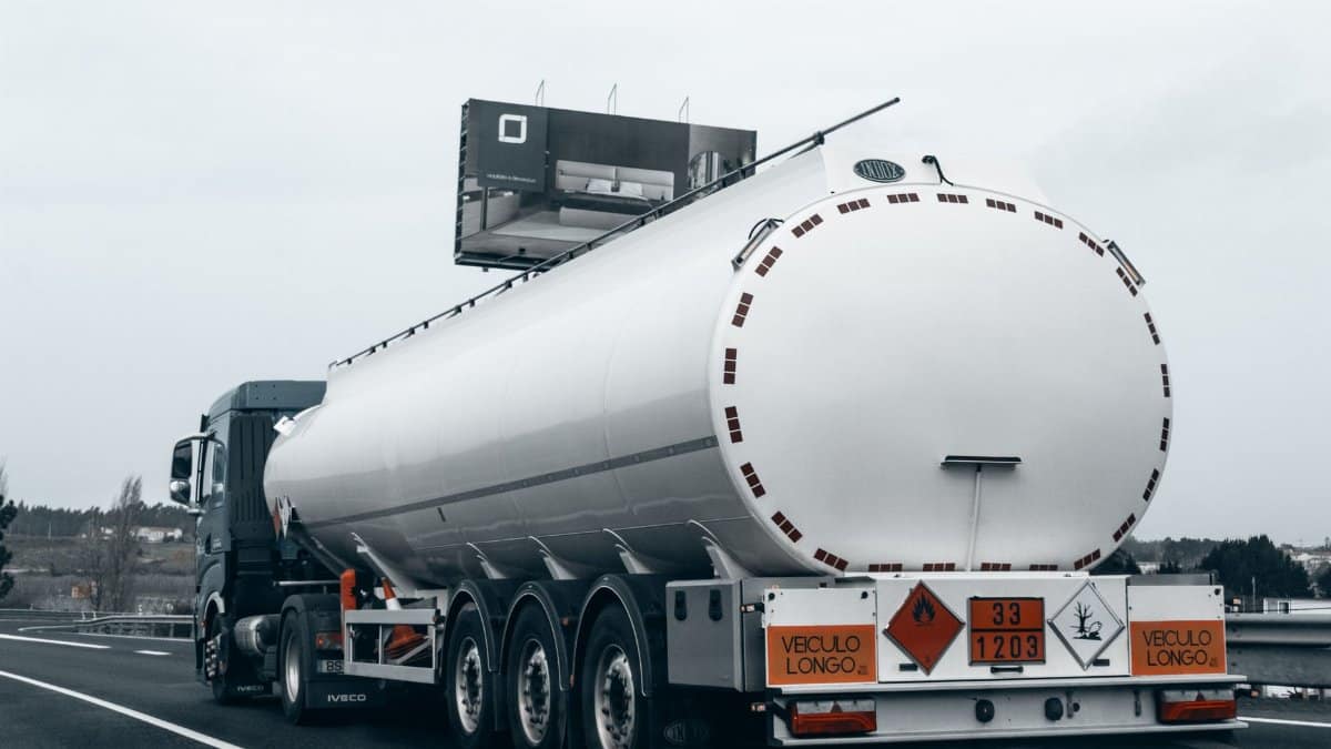 Rear view of a large tanker truck transporting fuel on a highway, emphasizing logistics and transportation.