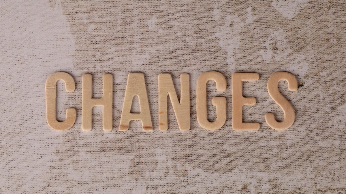 Wooden letters arranged to form 'Changes' on a textured, rustic surface.