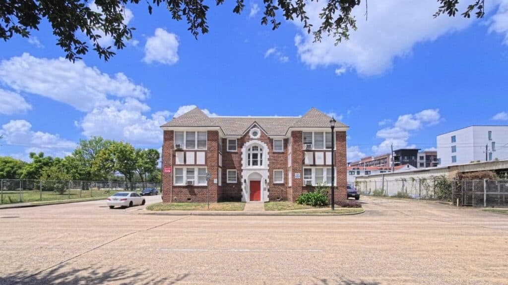 Front view of a vintage brick building under a clear blue sky in Houston, Texas.