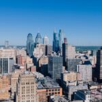 Stunning aerial view of Philadelphia's iconic skyline with modern skyscrapers under a clear blue sky.