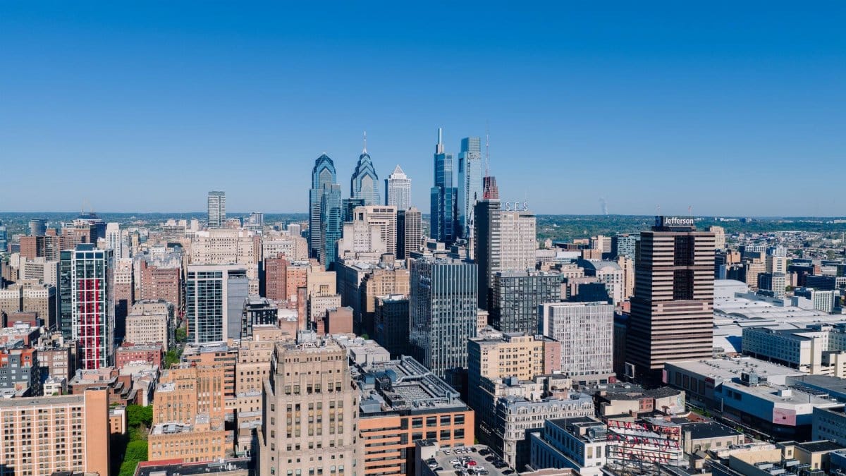 Stunning aerial view of Philadelphia's iconic skyline with modern skyscrapers under a clear blue sky.