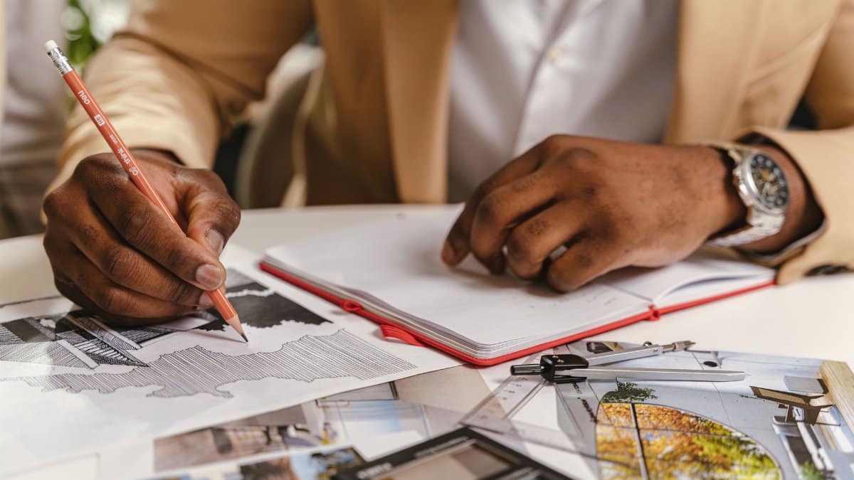 Architect sketching blueprints and planning in an office environment.