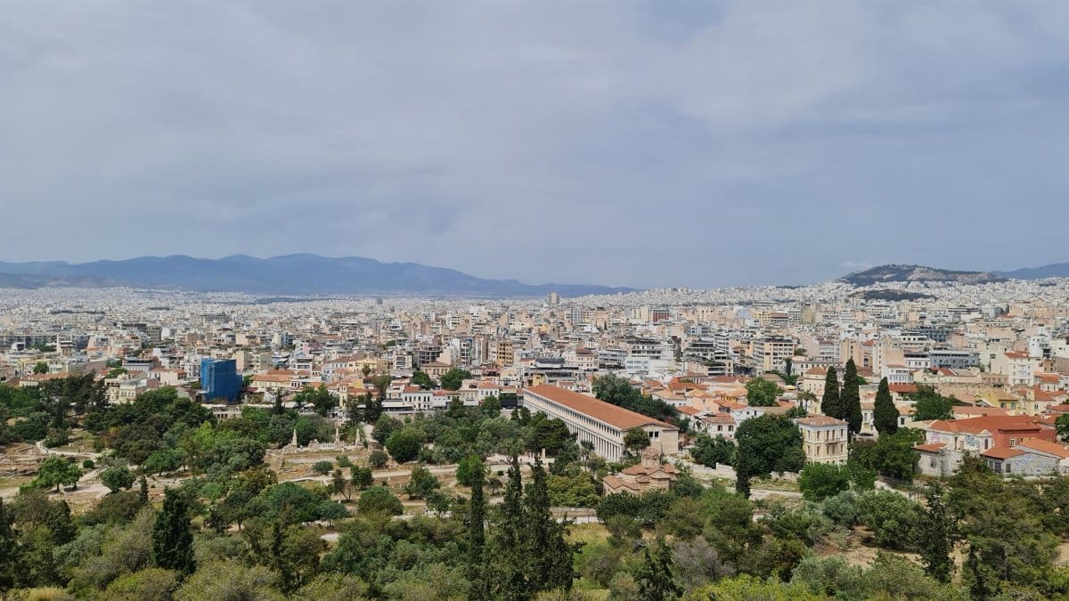 Aerial view of Athens showcasing cityscape, historical landmarks, and lush greenery.