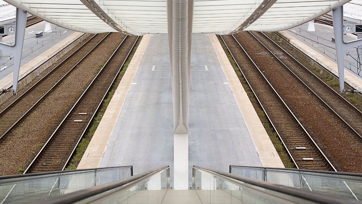 View from an escalator of a modern railway station showcasing symmetrical design.