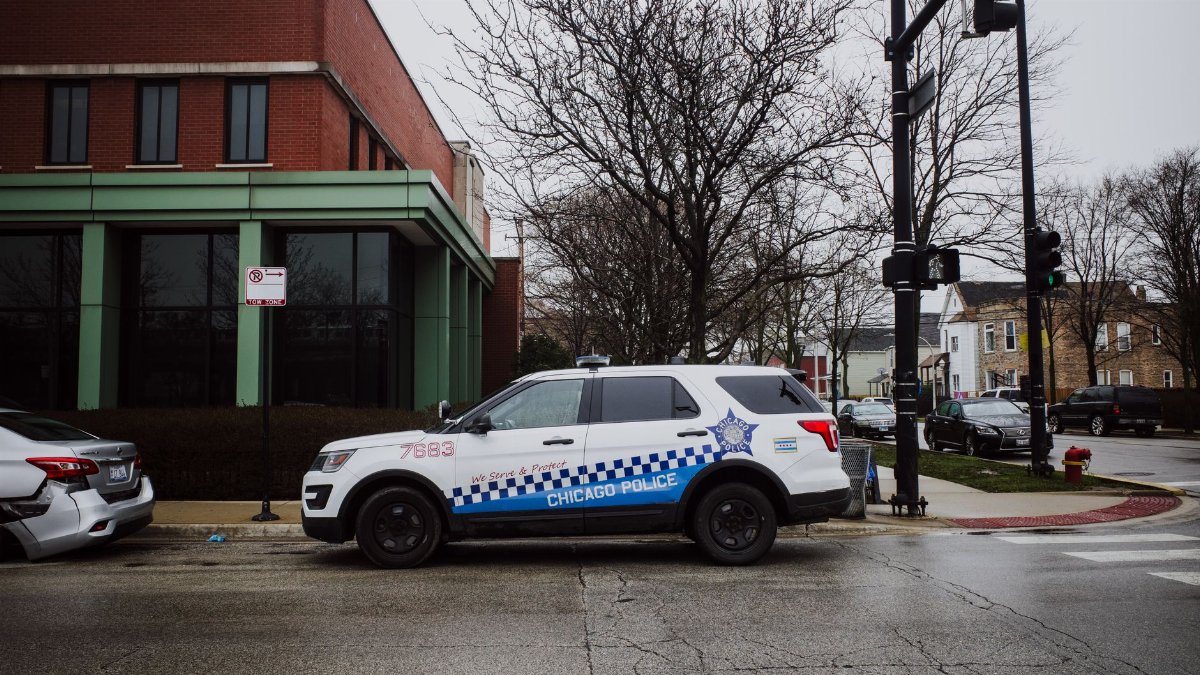 A Chicago police SUV parked on a city street near an intersection on a cloudy day.
