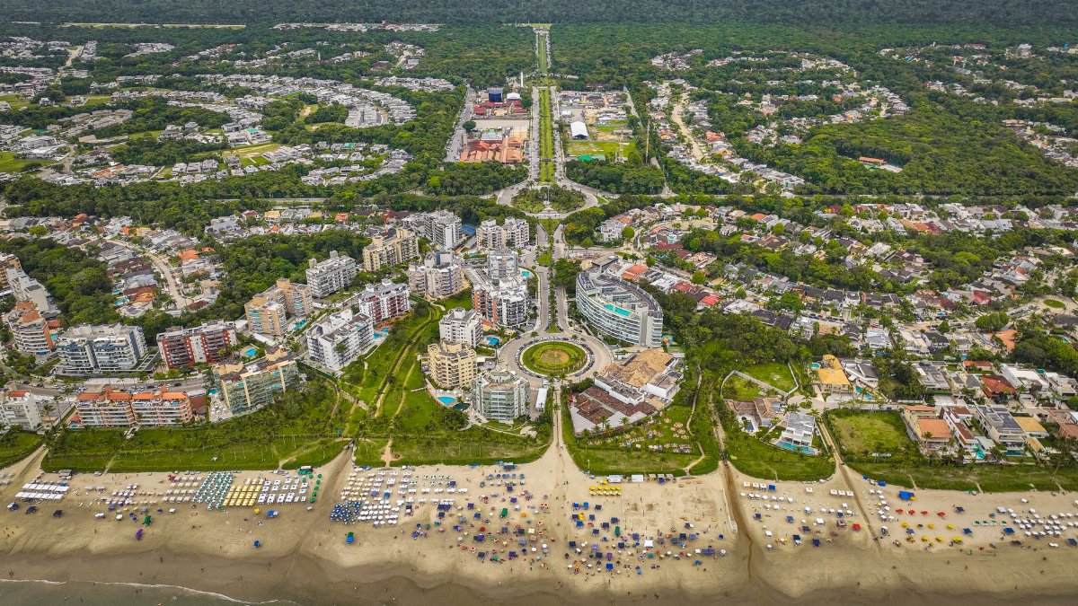 Vibrant aerial shot of a coastal city with beachfront and lush greenery.