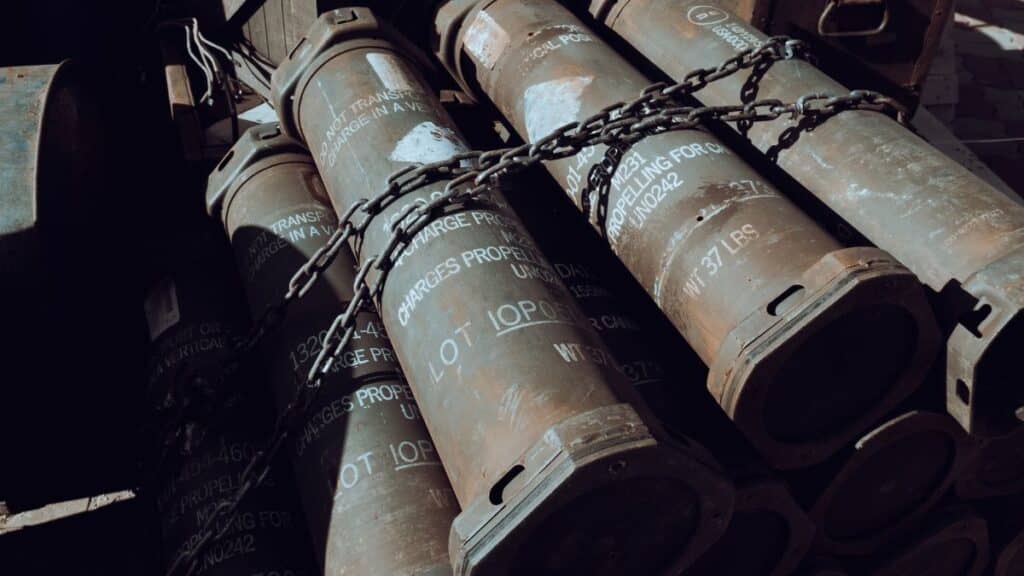 Close-up of chained military missile containers in a warehouse.