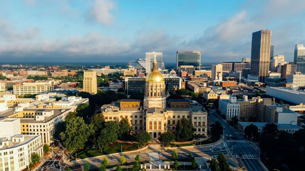Stunning aerial view of the Georgia State Capitol in downtown Atlanta under a clear blue sky.
