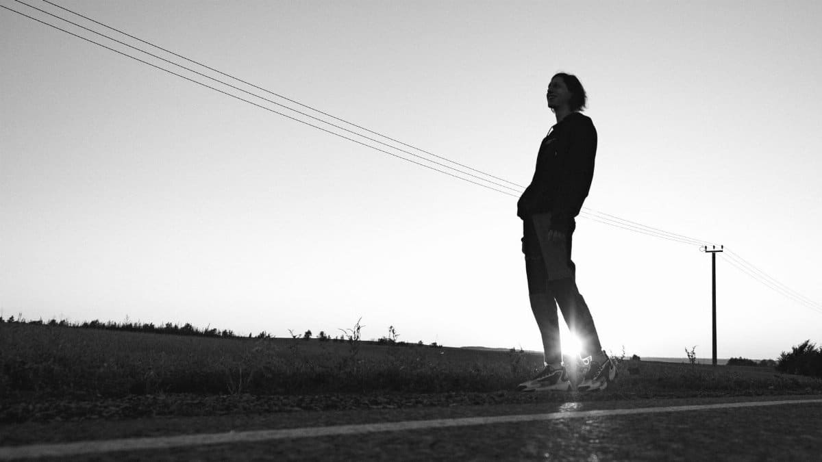 Captivating silhouette of a man standing on a road, set against a beautiful sunset.