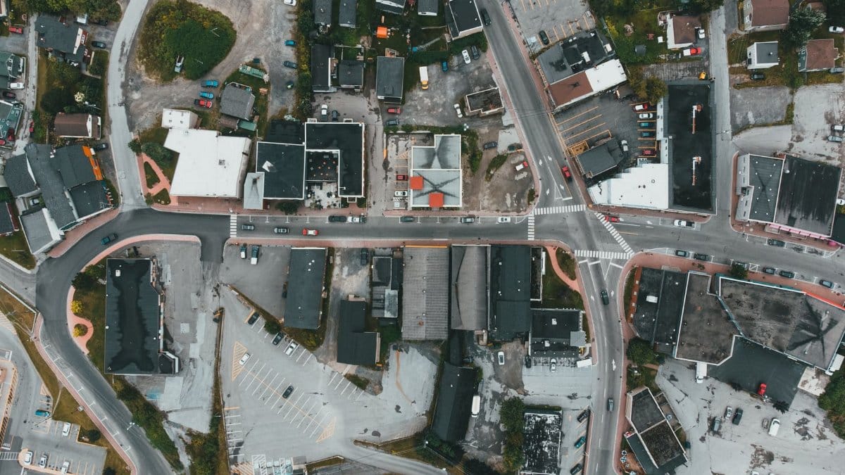 Overhead view of a busy urban intersection surrounded by buildings and parking lots.