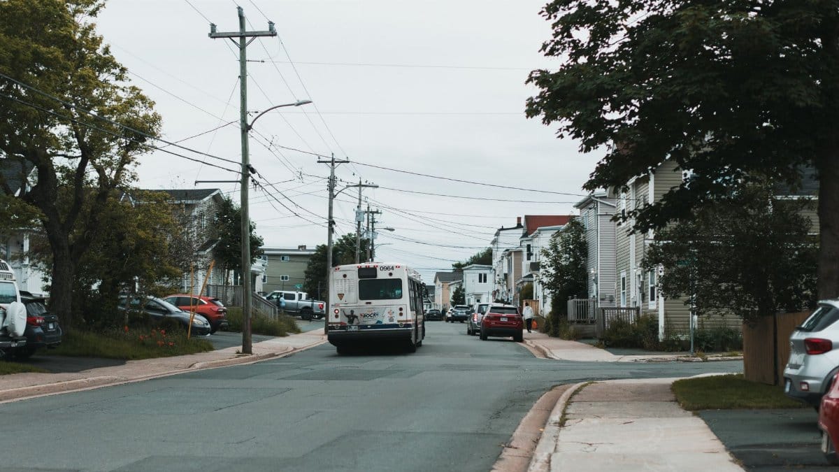 A serene neighborhood view with a bus on a street in St. John's, NL, Canada.