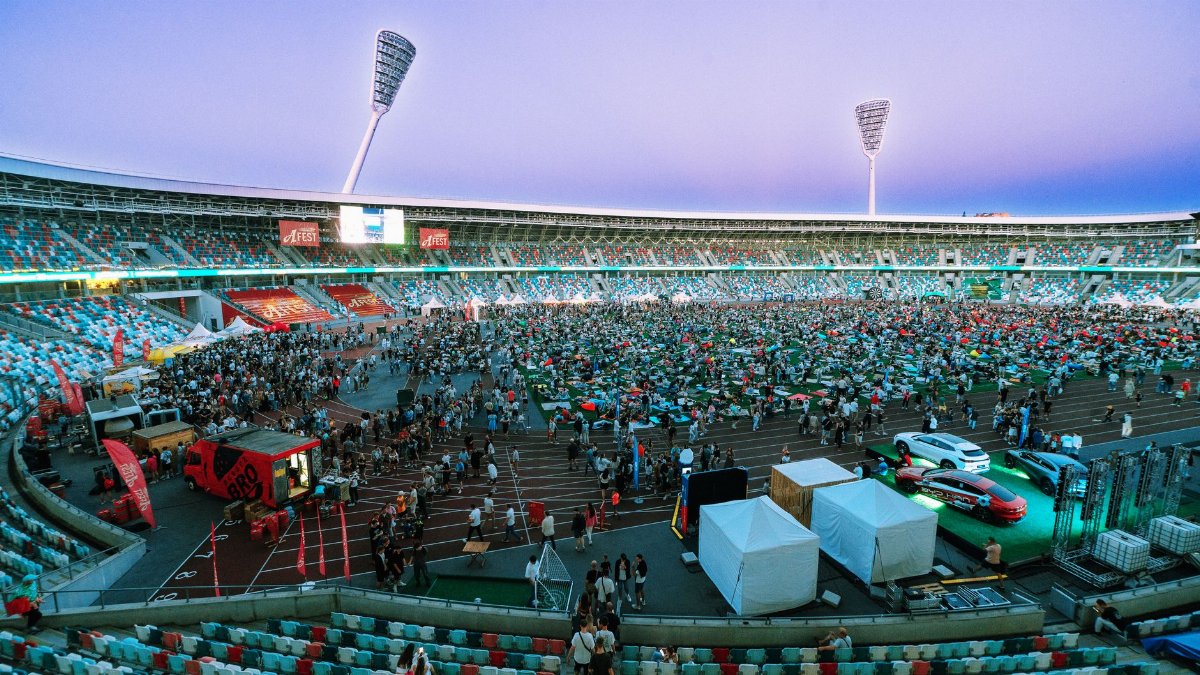 Aerial view of a large crowd gathering in a stadium during twilight. Perfect for event and sports themes.
