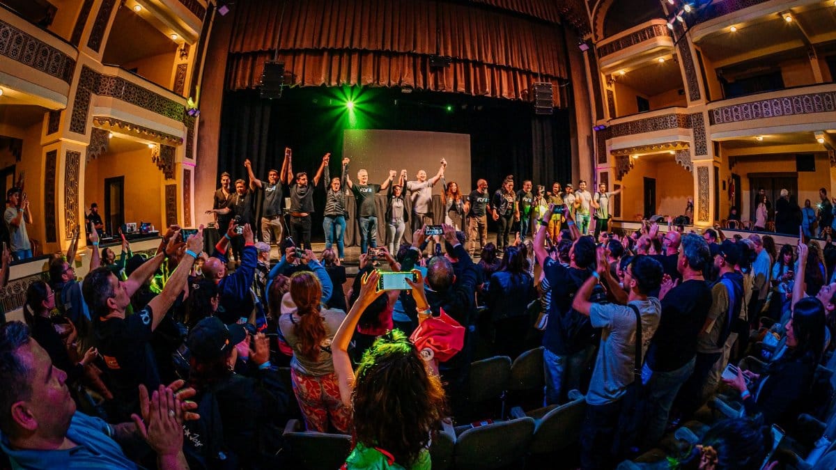 Dynamic theater scene with audience applauding performers on stage.