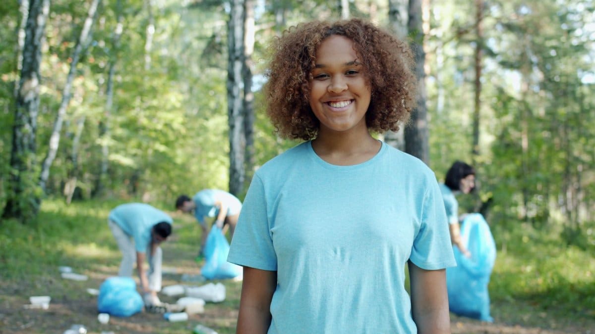 Group of volunteers cleaning up a forest, promoting environmental awareness.