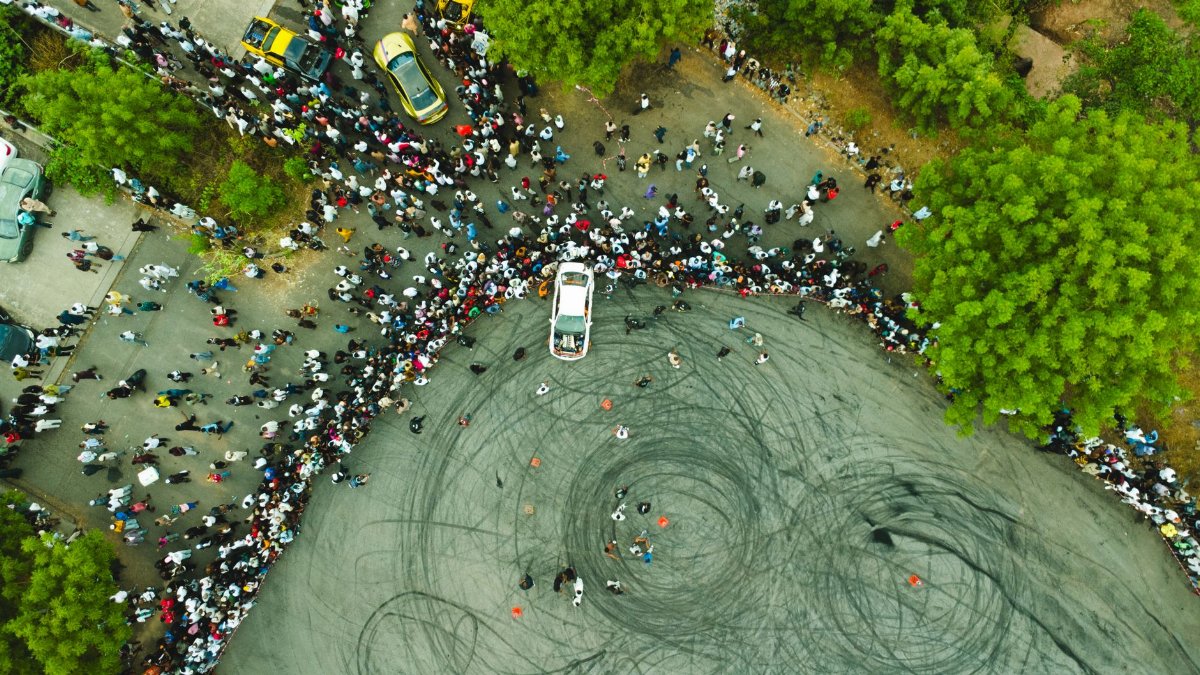 Aerial shot of a large crowd gathered for a car drifting event in Abuja, Nigeria.