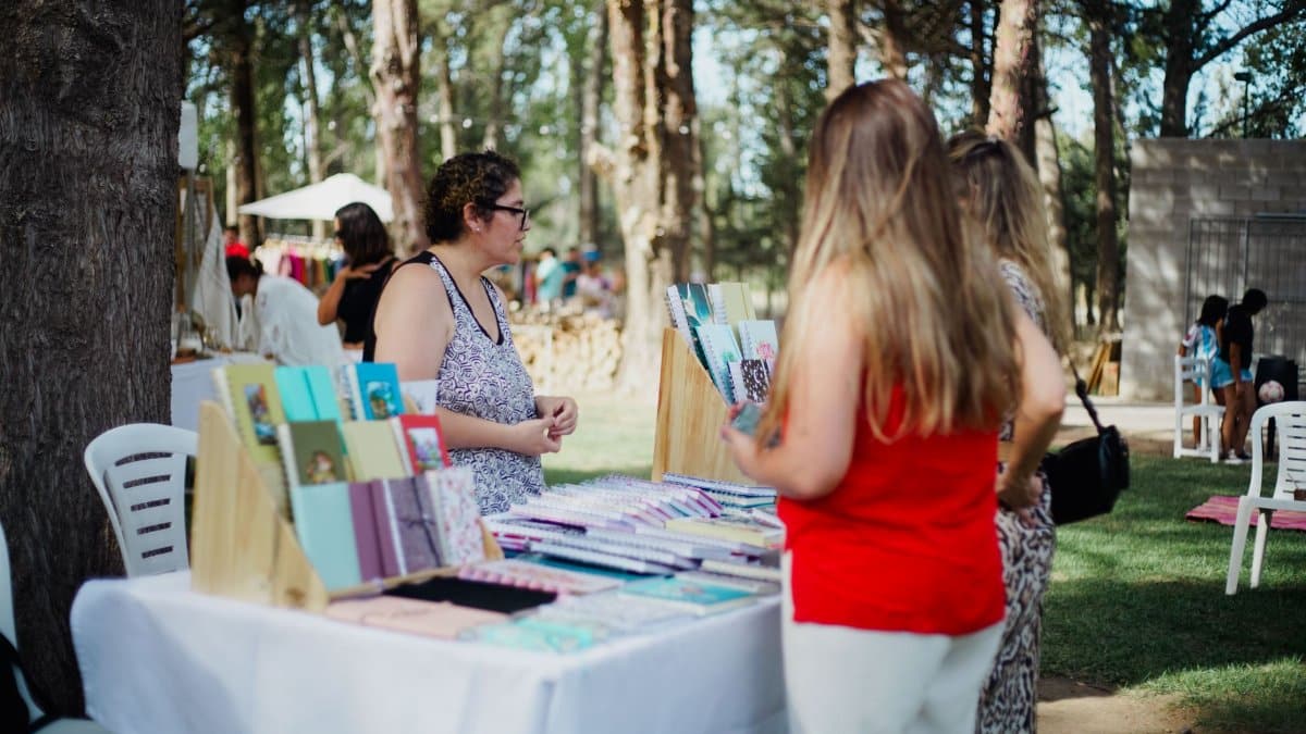 A vibrant outdoor market scene showing notebooks on display with people browsing.