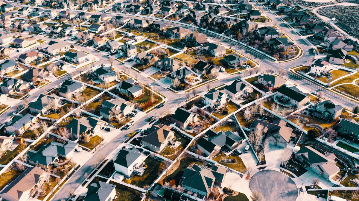High-angle aerial shot of a suburban neighborhood in Herriman, Utah showcasing residential architecture and streets.