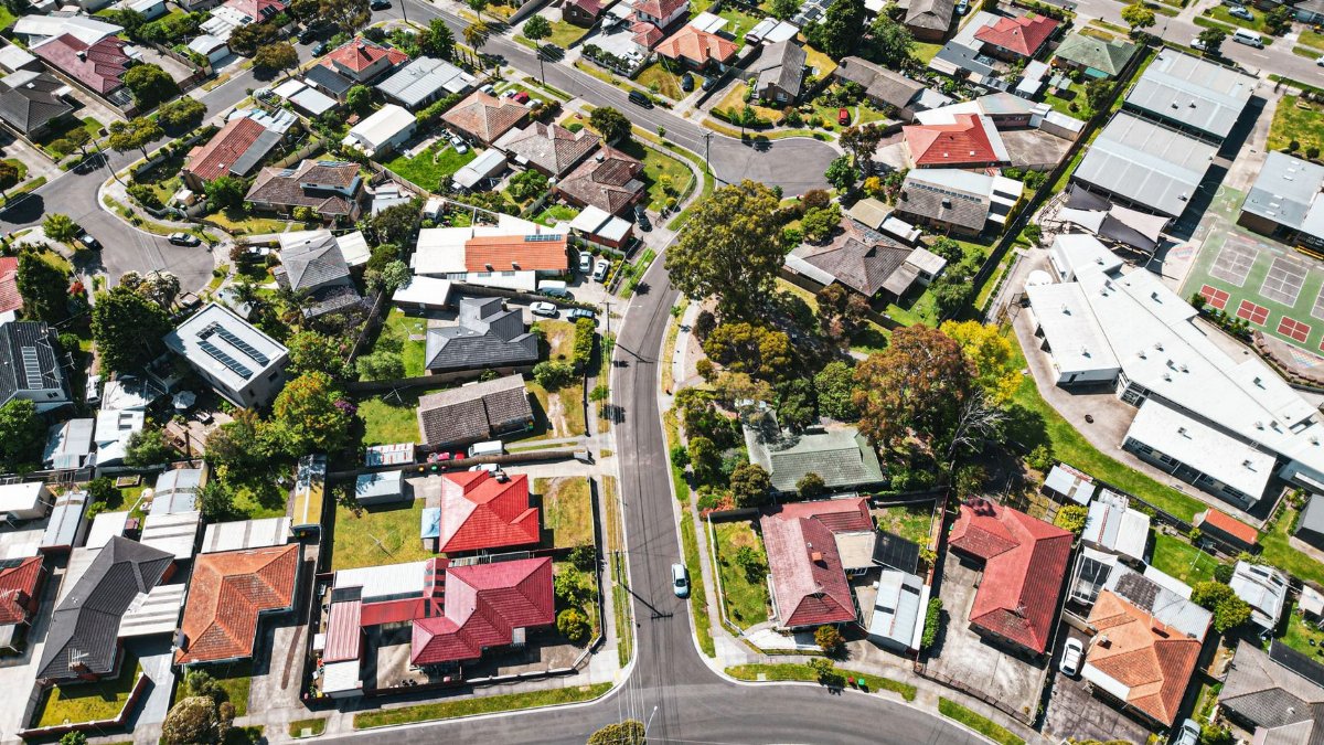 Drone shot capturing vibrant suburban area in Melbourne, Australia, showcasing varied architecture and greenery.