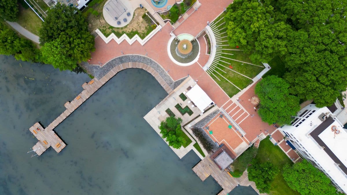 Bird's eye view of a vibrant park and lake pier in Columbia, Maryland during summer.