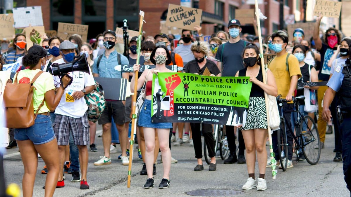 Protesters in Chicago demand police accountability in a peaceful march. Participants hold signs and banners.