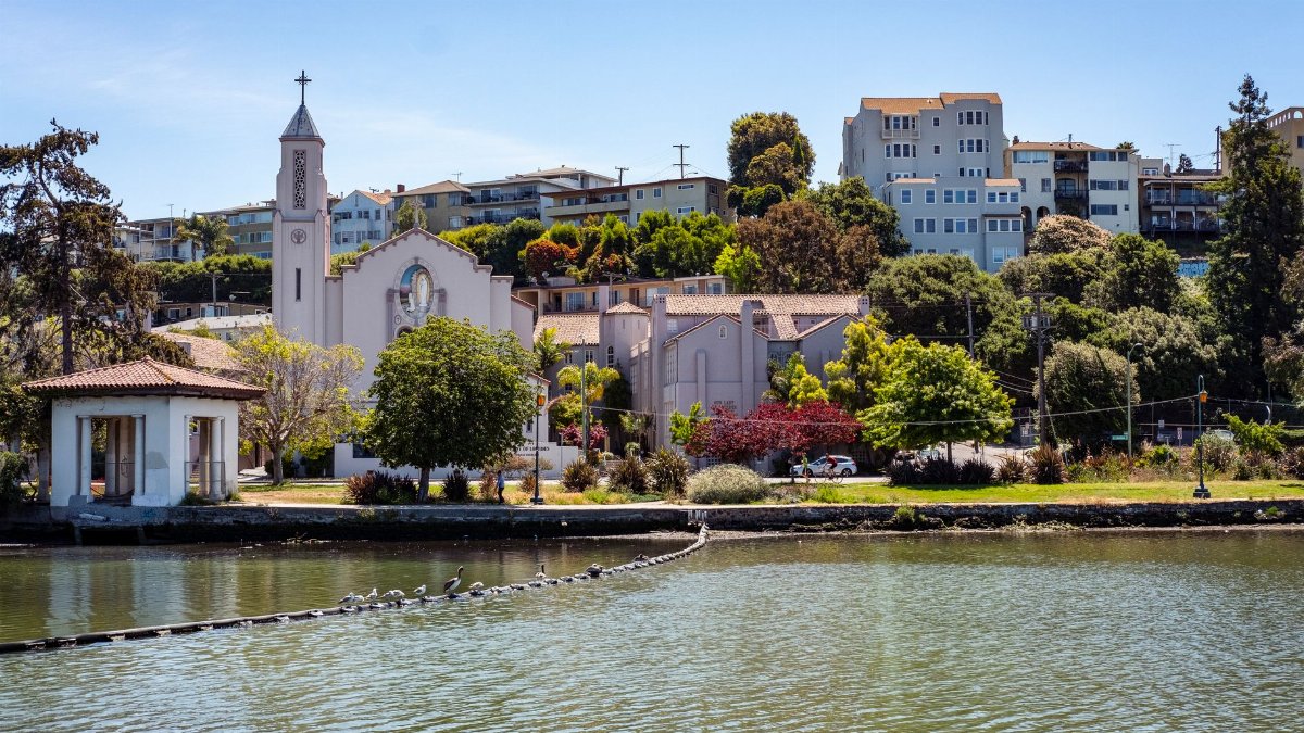 Beautiful view of Our Lady of Lourdes Church and surrounding buildings by the waterfront in Oakland, California.