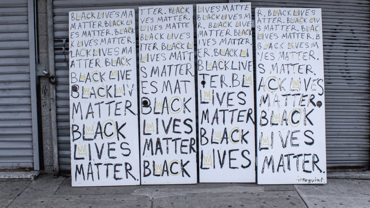 Protest signs with 'Black Lives Matter' text on a sidewalk in Philadelphia.