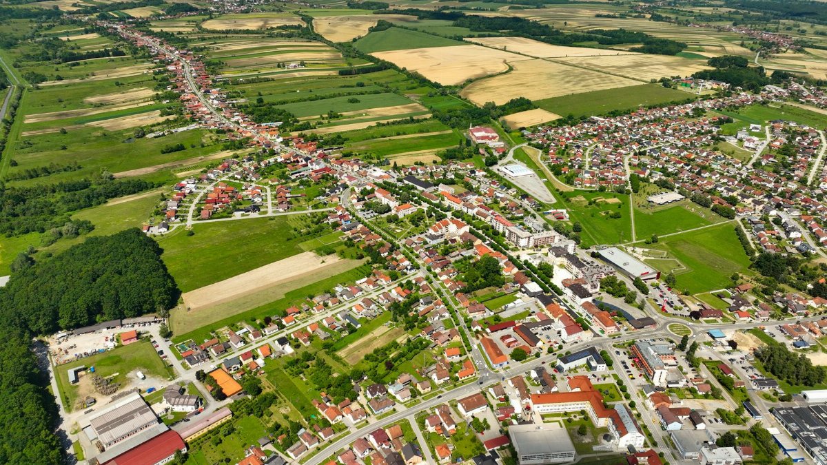 Explore the picturesque aerial view of Garešnica, Croatia's fields and town under a clear sky.