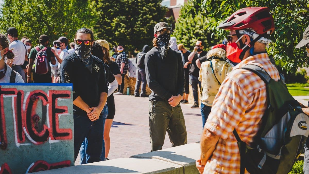 Crowded street with people in masks during meetings in defense of rights during coronavirus pandemic