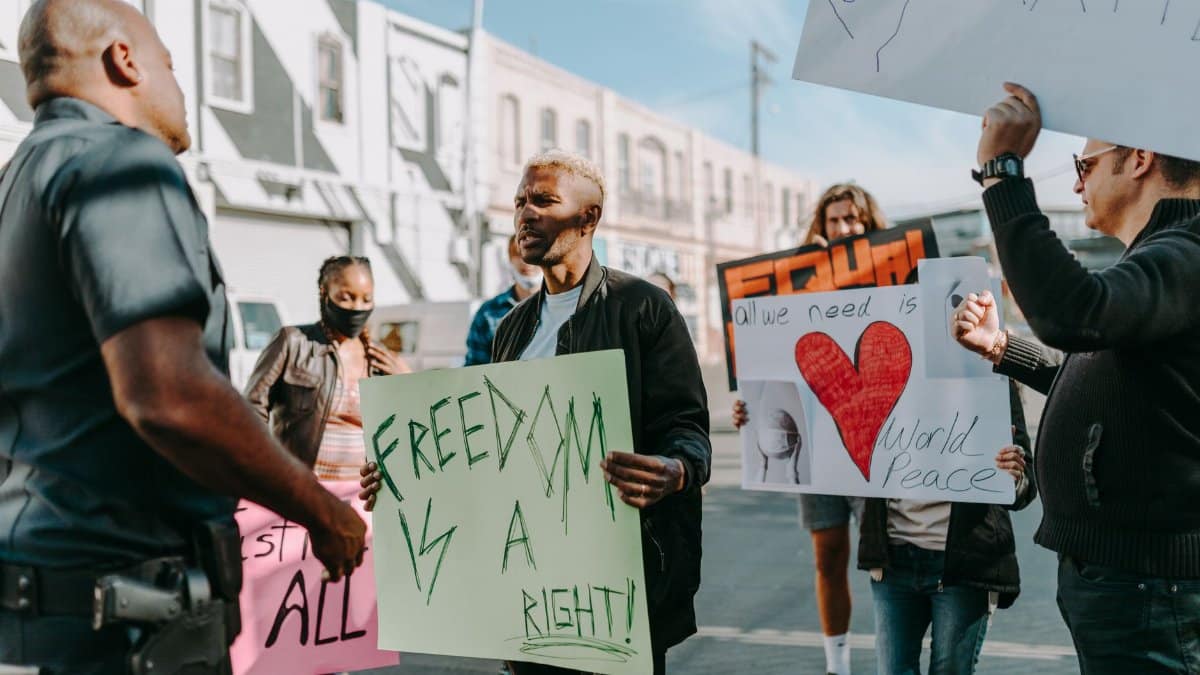 A diverse group of people peacefully protesting for freedoms and world peace in an urban setting.