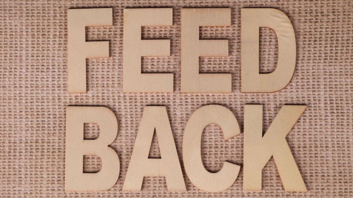 Wooden letters spelling 'FEEDBACK' on a burlap background, emphasizing communication.
