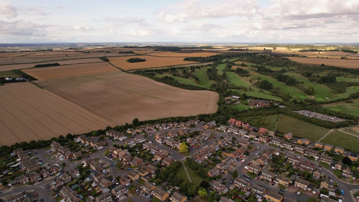 Aerial landscape shot of the expansive fields and residential area in Luton, England.
