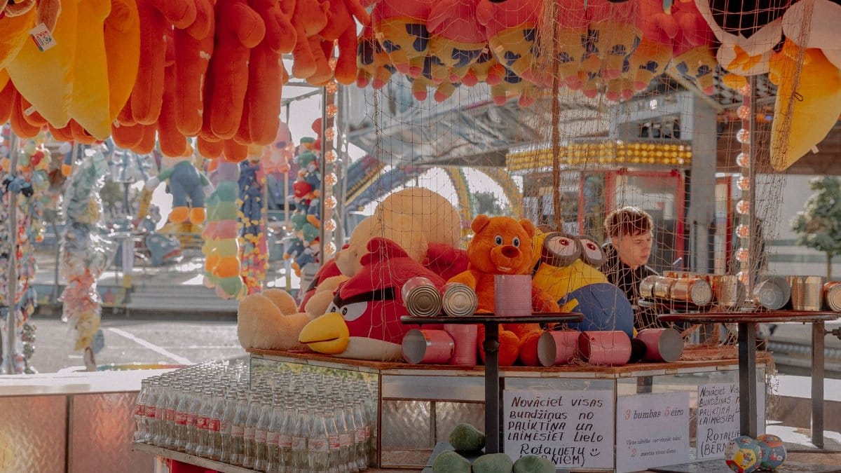 Carnival stall with plush toys and prizes on display, attracting visitors with fun and vibrant colors.