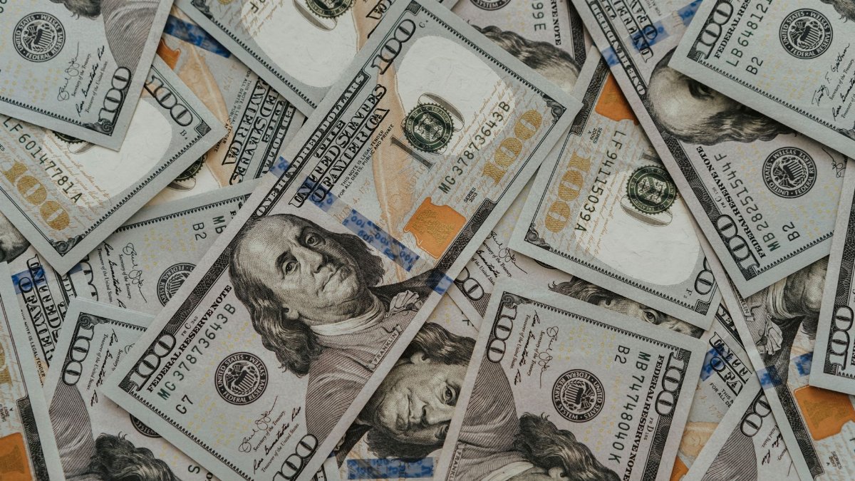 Close-up of American 100 dollar bills scattered, highlighting wealth and currency concepts.