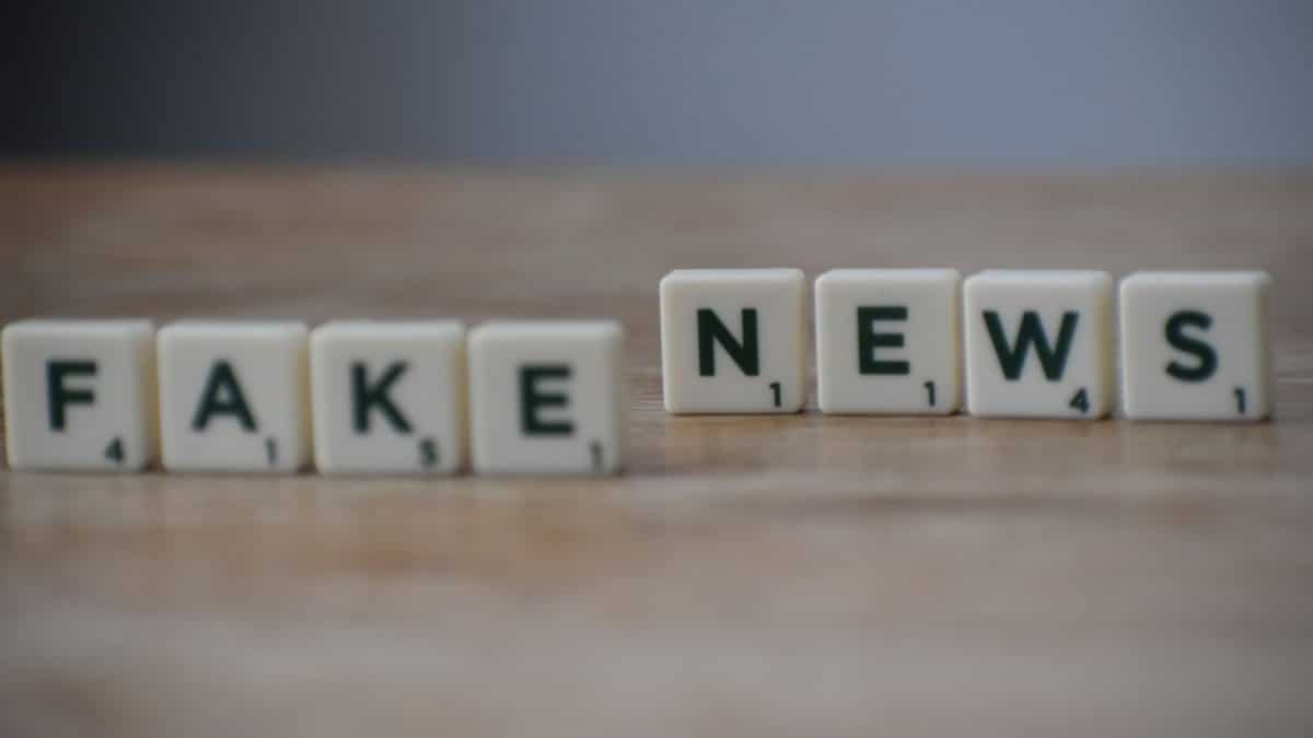 Scrabble tiles spelling 'Fake News' on a wooden surface highlighting misinformation.