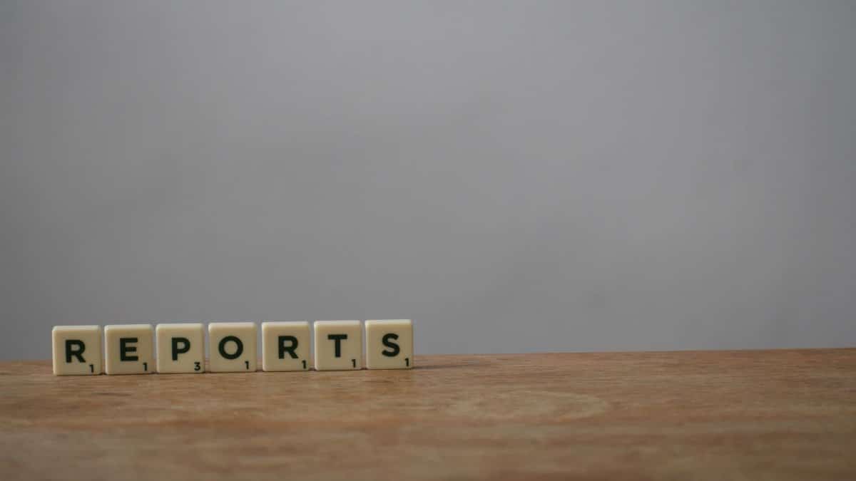 Scrabble tiles spelling 'reports' on a wooden desk, ideal for office or business themes.