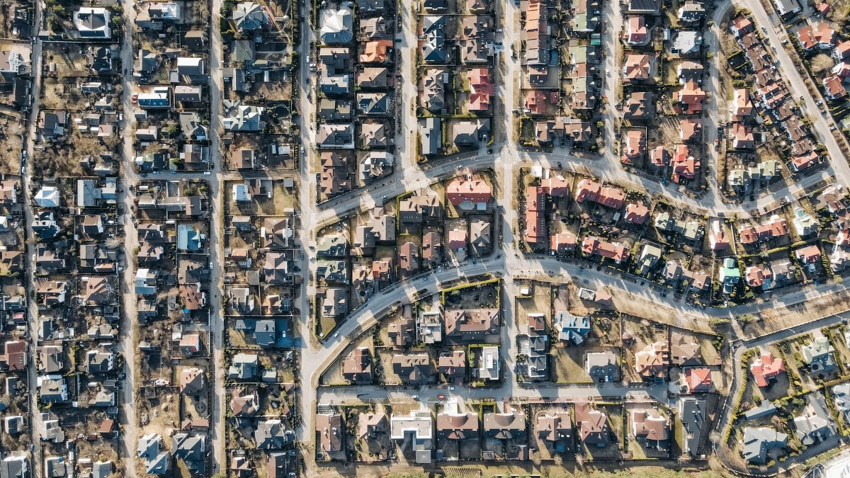 Aerial view showcasing a suburban residential neighborhood with neatly arranged houses and curving roads.