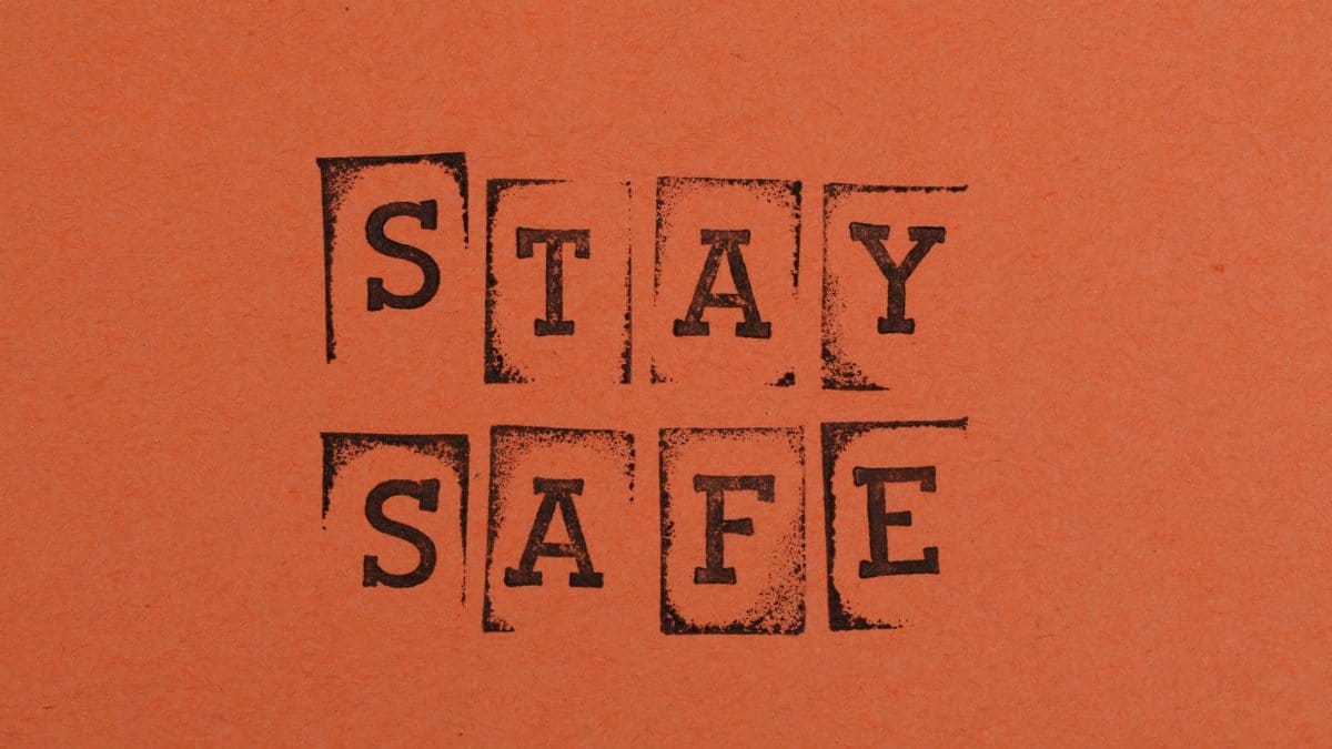 Textured 'Stay Safe' message on an orange background, emphasizing safety and awareness.