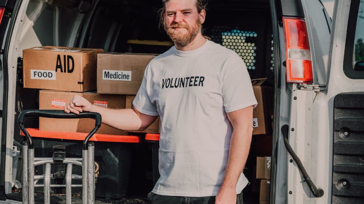 Volunteer standing by a van loaded with aid supplies, ready to serve the community.