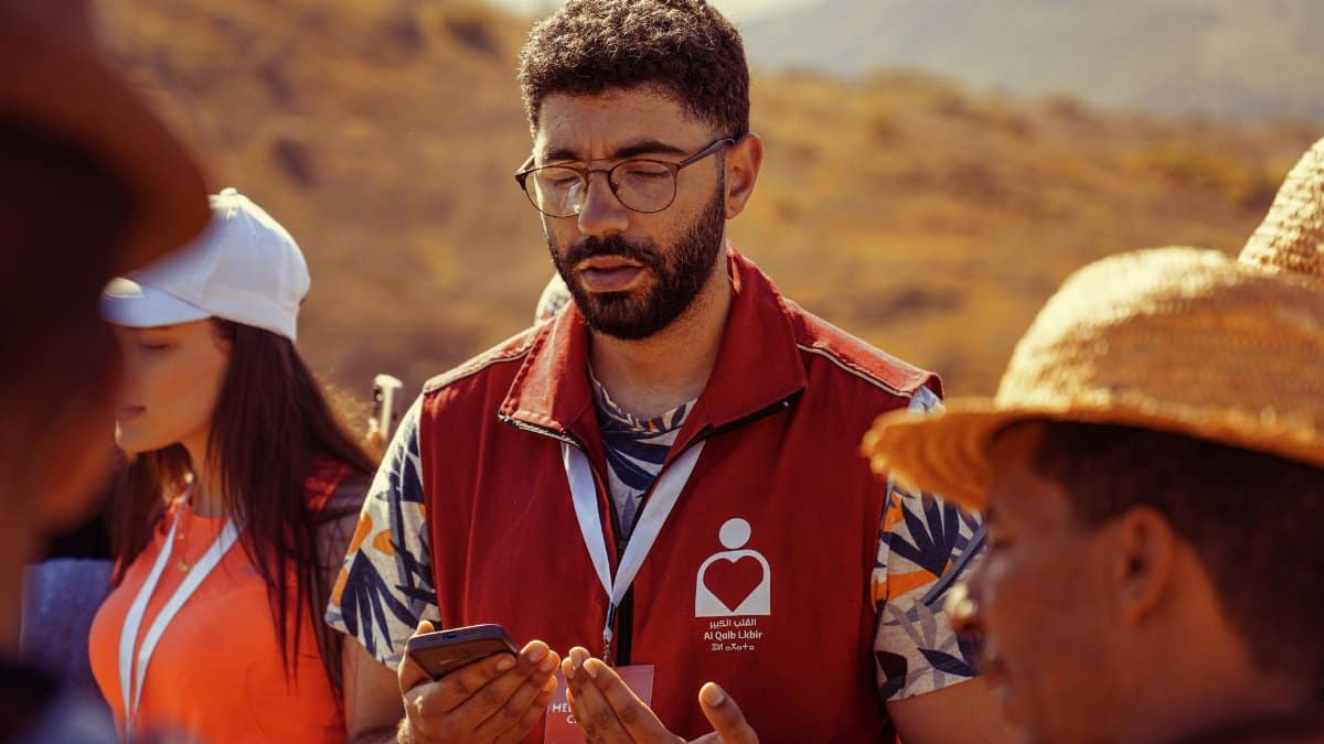 Volunteers gathered outdoors for a community meeting, promoting teamwork and collaboration.